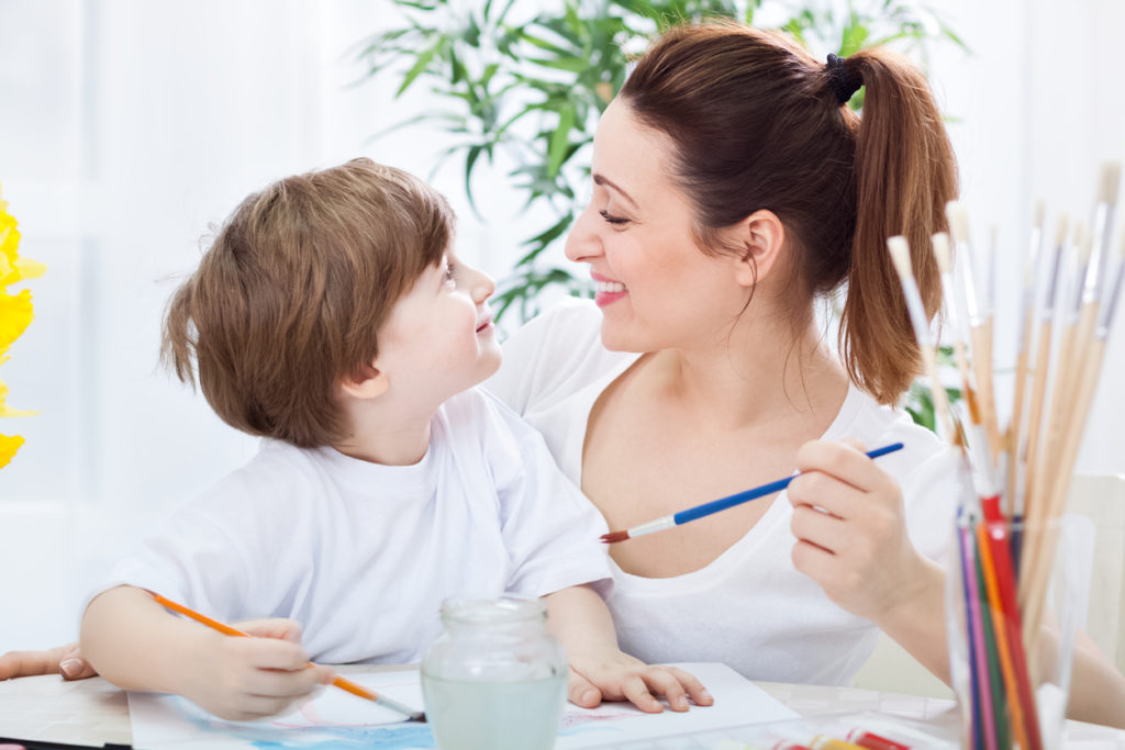 Mamma e figlio dipingono e sorridono insieme